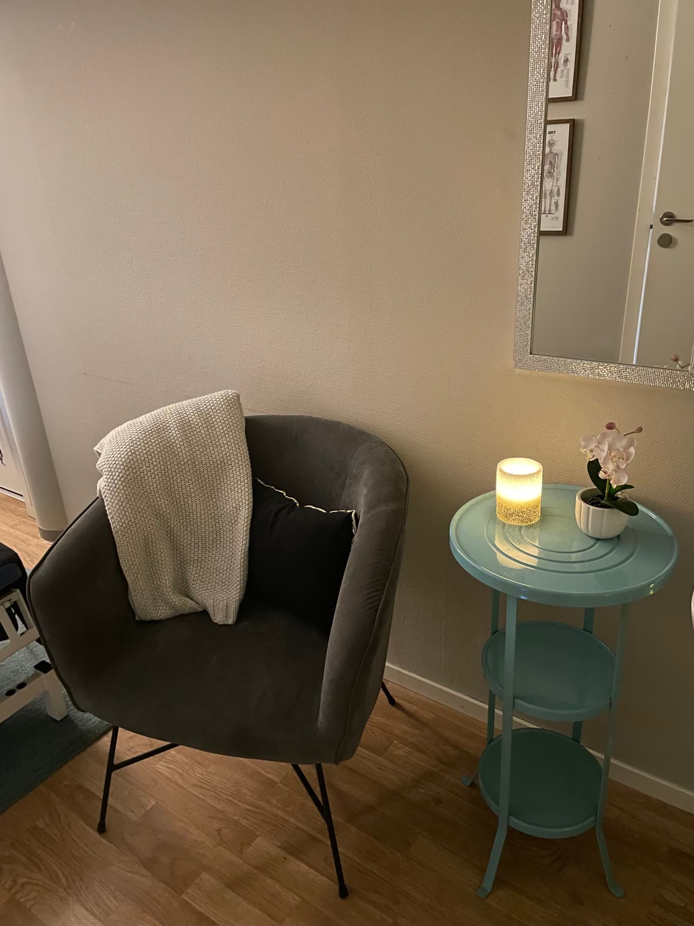 En lugn vrå i mottagningen med fåtölj, tänd lykta och en orkidé
